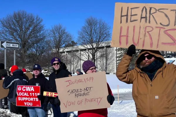 People standing on picket line with signs in the snow